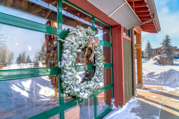 建筑物玻璃墙上结霜的花环，反映了冬季的风景 — 图库照片