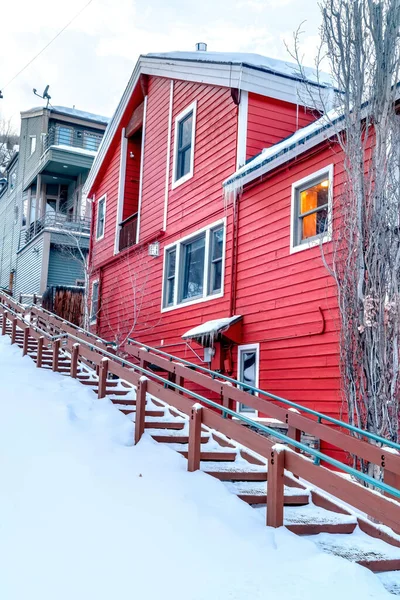 Kışın bulutlu gökyüzüne karşı karlı bir tepede açık merdiven ve rahat evler. — Stok fotoğraf