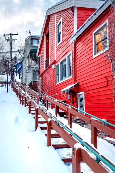 Schody zewnętrzne wzdłuż kolorowych domów na pokrytym śniegiem zboczu wzgórza w zimie — Zdjęcie stockowe