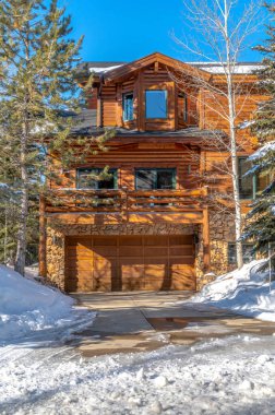 Park City 'de ahşap bir evin ön cephesinde garaj kapısı balkon ve koy penceresi.