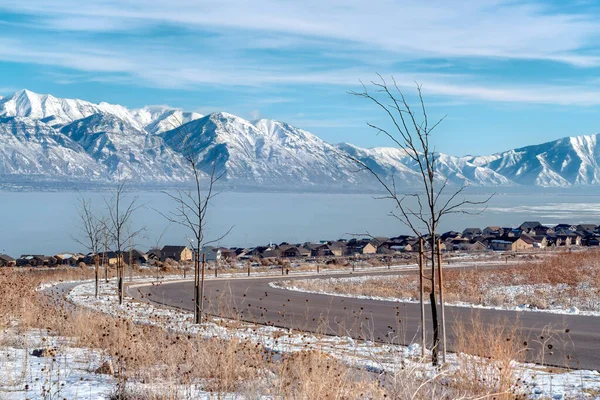 Carretera y casas ovelooking nevado Wasatch Mountains y azul Utah Lake en invierno —  Fotos de Stock