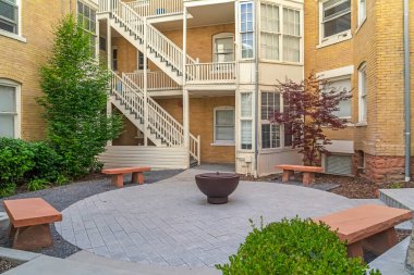 Sarı tuğlalı duvarlı ve merdivenli, taş banklı ateş çukuru.