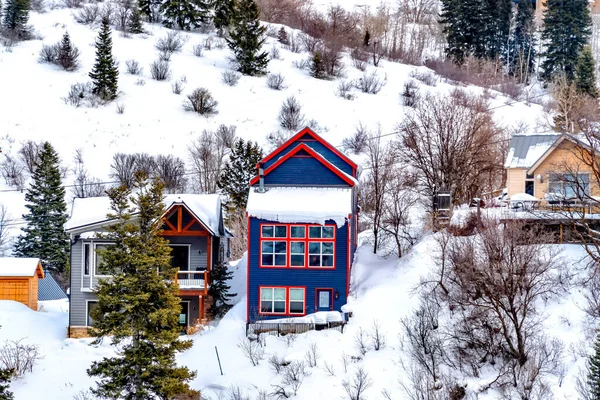 Coloridas casas de barrio enclavadas en la ladera de colinas nevadas vistas en invierno — Foto de Stock