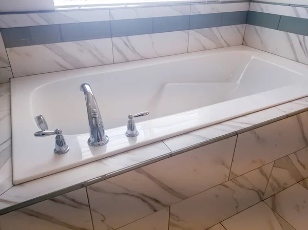 Закрыть встроенную прямоугольную ванну с краном и ручками из нержавеющей стали — стоковое фото