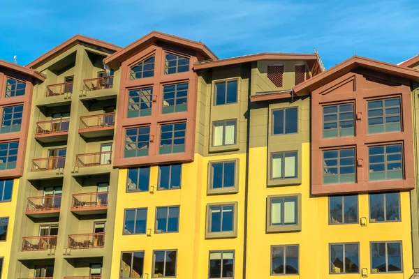 Lakóépület többszínű fallal és kis erkéllyel a kék ég ellen — Stock Fotó