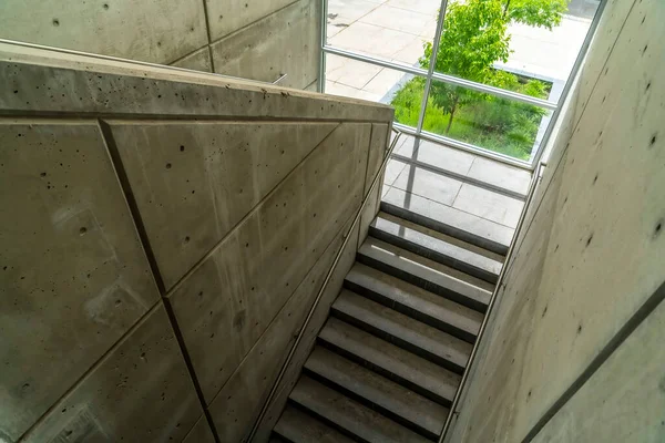 Edifício comercial interior com escadaria e corrimãos entre paredes de concreto — Fotografia de Stock