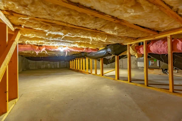 上層階の断熱材と木製の支持梁を備えた地下またはクロールスペース — ストック写真
