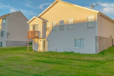 Güneşli bir günde beyaz duvar kenarlı çatı ve küçük balkon manzaralı ev