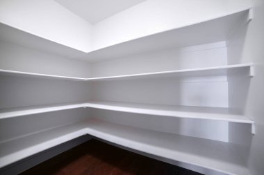 İç odada boş beyaz raflar var.