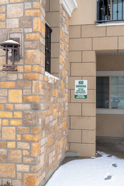 Vista exterior de los apartamentos con cartel de No Fumar en la pared de ladrillo de piedra — Foto de Stock