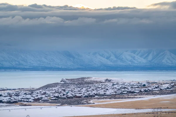 Scénická utah údolí krajina se zasněženými horami zamrzlé jezero a matné domy — Stock fotografie