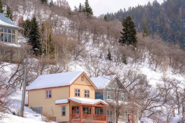 Park City Utah dağ mahallesinde verandalı ve karlı çatılı evler.