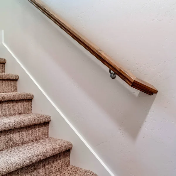Main courante en bois brun carré d'escalier et interrupteur de lumière à bascule contre la paroi intérieure — Photo