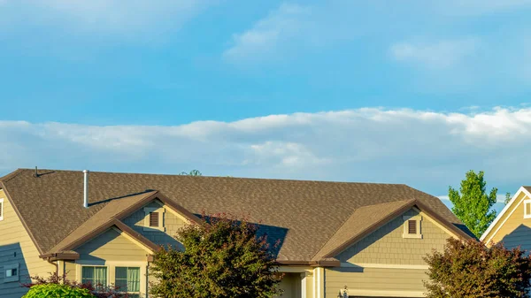 Cultivo panorámico Techo gris de la casa iluminada por el sol con un vasto fondo de cielo azul nublado en un día soleado — Foto de Stock