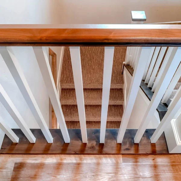 Escalier carré en forme de U avec balustrade blanche marron et tapis sur les marches — Photo