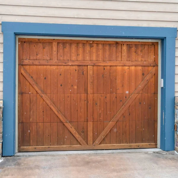 Дверь гаража из дерева Square Brown с синей рамкой, обтянутой настенными винтажными фонарями — стоковое фото