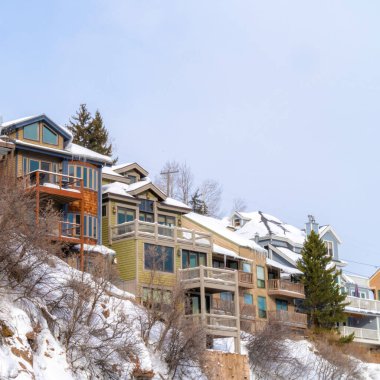 Karlı çatıları ve manzaralı Park City Utah mahallesinde balkonları olan kare evler.