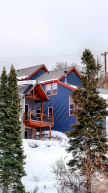 Dikey ekin evleri kışın Utah Park şehrinde yemyeşil tepede karla kaplı.