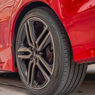 Kare çerçeve Parlak kırmızı araba dış tarafı siyah lastik tekerlekleri yola yakın