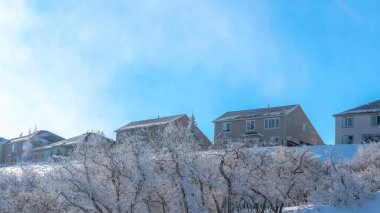 Panorama Mavi gökyüzü ve karla kaplı evlerin üzerindeki parlak güneş kışın Wasatch Dağı 'nı kapladı.
