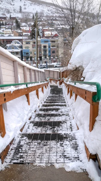 Vertical crop Outdoor stairs overlooking snowy Park City neighborhood and mountain in winter