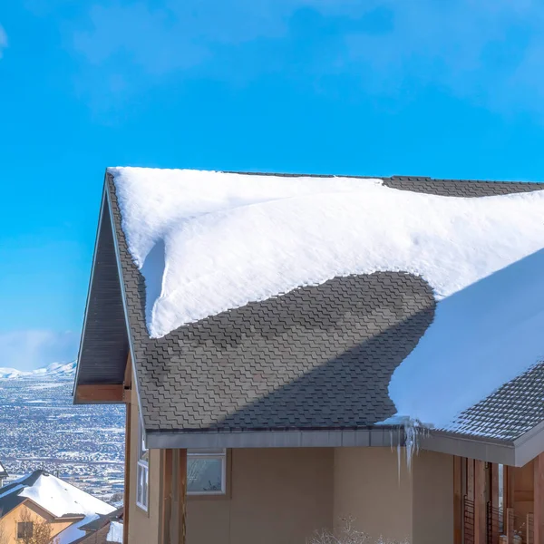 Square Sunlit gray pitched roof of a home with mound of fresh snow at winter season — Stock Photo, Image