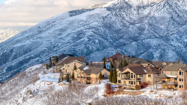 Panorama cultivos Casas enclavadas en medio de prístina Wasatch Mountain vistas cubiertas de nieve en invierno — Foto de Stock