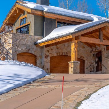 Park City Utah 'taki kare dağ evi garaj girişine giden yolu gösteriyor.