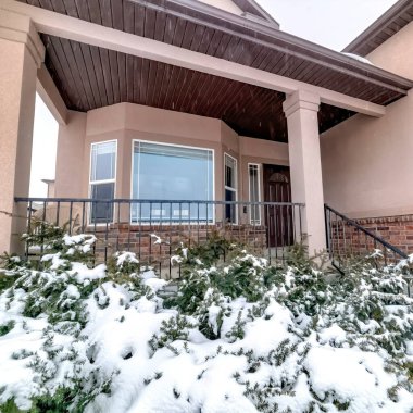 Kare mahsul Karlı Evergreen tuğla evin bahçesinde pencere ve verandalı