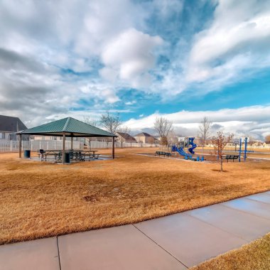 Çadır boyunca patikası olan kare ekin parkı manzarası ve eriyen karlı oyun alanı