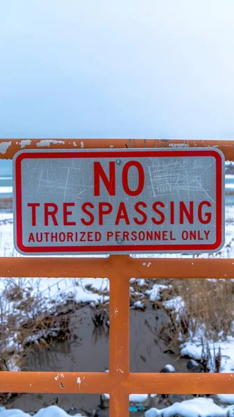 Vertical No Trespassing signage on a fence against Utah Lake and snowy shore background — Stock Photo, Image