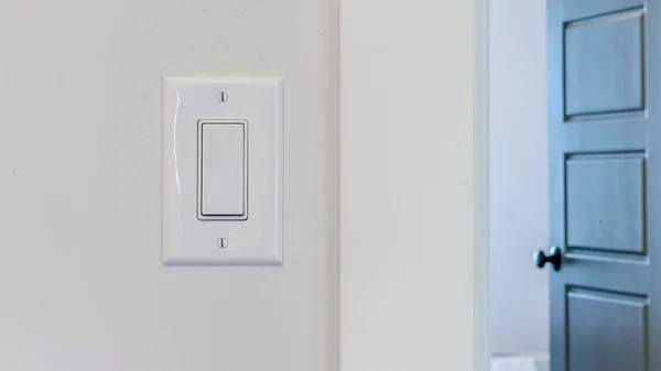 Panorámakeret Elektromos rocker villanykapcsoló fehér falon szemben elmosódott ajtó háttér — Stock Fotó