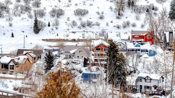 Panorama Park City barrio en la colina nevada iluminado por coloridos hogares y árboles perennes — Foto de Stock