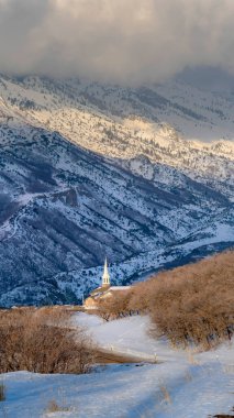 Dikey ekin muhteşem Wasatch Dağı ve kabarık bulutlar kışın manzaralı bir kasabanın üzerinde