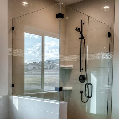 Square crop Rectangular walk in shower stall with half glass enclosure and black shower head clipart