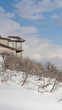 Vadiyi ve Wasatch Dağlarını gören Mountainside evi bulutlu gökyüzünün altında.