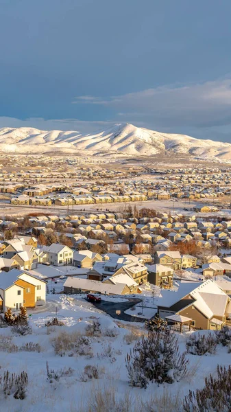 Svislý západ slunce v malebném údolí Utahu s domy a horami pokrytými zimním sněhem — Stock fotografie