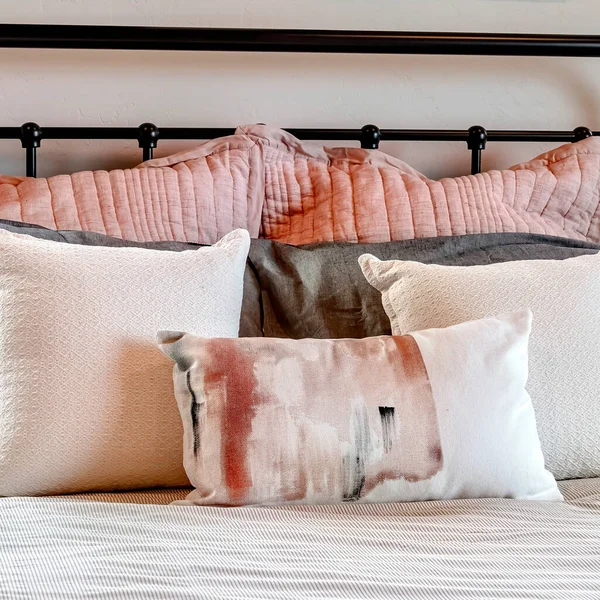 Square frame Single bed with fluffy pillows against black metal headboard inside bedroom — Stock Photo, Image