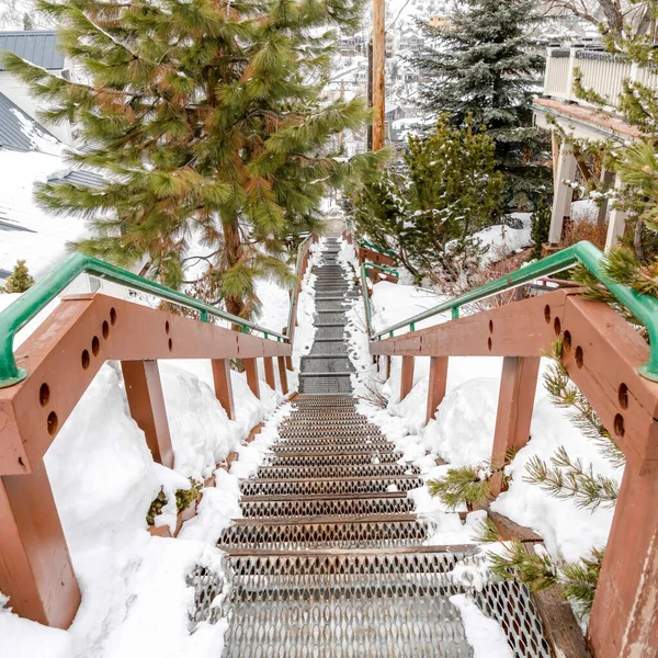 Escadaria quadrada na colina com vista para os telhados casas e árvores com neve fresca no inverno — Fotografia de Stock