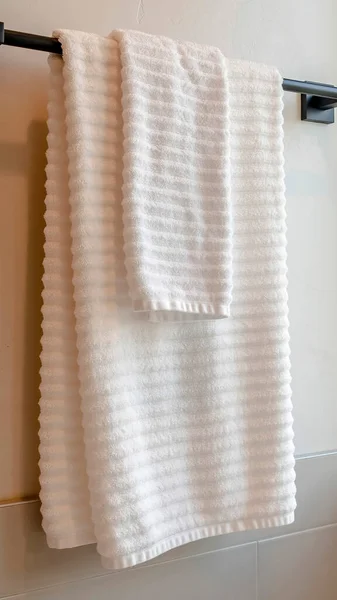 用瓷砖把白色毛巾挂在浴室墙壁上的垂直黑色杆子 — 图库照片