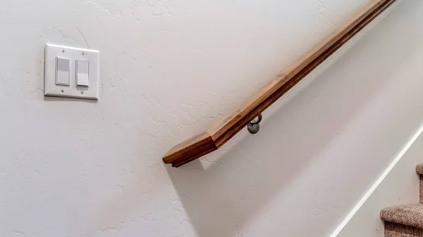 Панорама Браун деревянные перила лестницы и рокер выключатель против внутренней стены — стоковое фото