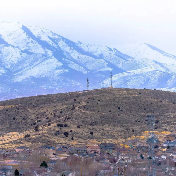 Cultivo cuadrado Panorama de casas y terreno montañoso con magnífico fondo de montaña nevada —  Fotos de Stock