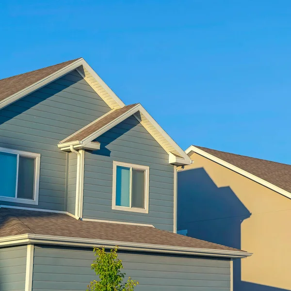 Square Homes med horisontella vägg sidospår och främre gavel tak mot klarblå himmel — Stockfoto