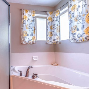 Küvette ve duş kabininde çerçevelenmiş cam kaplamalı kare banyo.