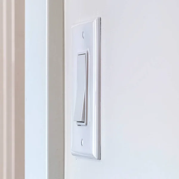 Square frame Side view of electrical rocker light switch mounted on white interior wall — Stock Photo, Image