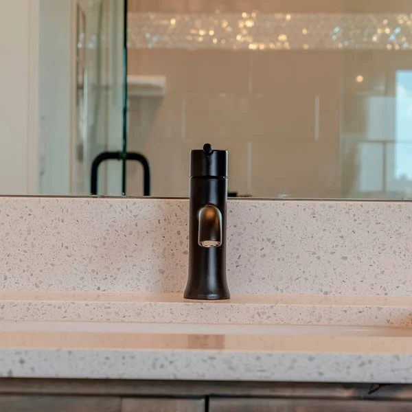 Quadratischer schwarzer Wasserhahn auf weißer Arbeitsplatte mit Unterbodenwaschbecken im heimischen Badezimmer — Stockfoto