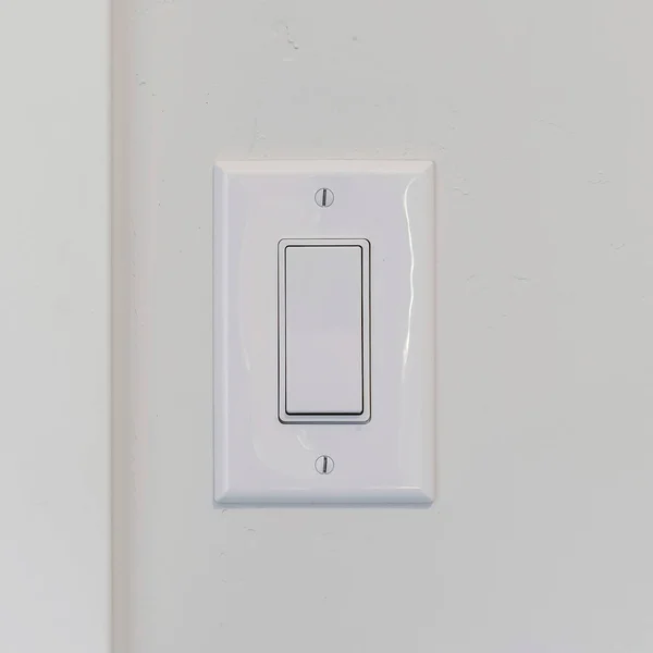 Square Electrical rocker ljus switch på vit vägg mot suddig dörr bakgrund — Stockfoto