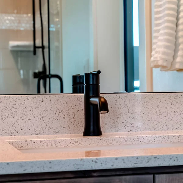 Coltivazione quadrata Lavello sottotetto con rubinetto nero su piano di lavoro bianco all'interno del bagno di casa — Foto Stock