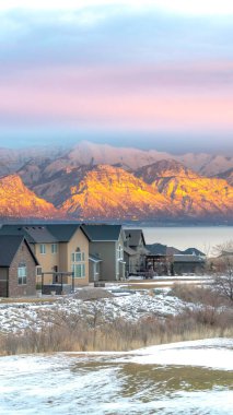 Sakin gölü ve altın kaplı dağ zeminiyle karlı vadide dikey evler