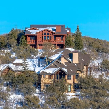 Park City 'deki Hill Tepesi' nin tepesindeki evler. Kışın kar ve mavi gökyüzü manzarasının ortasında.